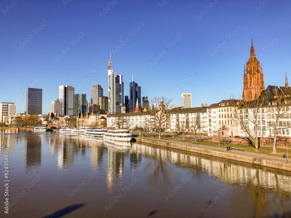 view to Frankfurt skyline with skyscraper and modern cityscape with river Main and cruise ships at pier view to Frankfurt skyline with skyscraper and modern cityscape with river Main and cruise ships at pier