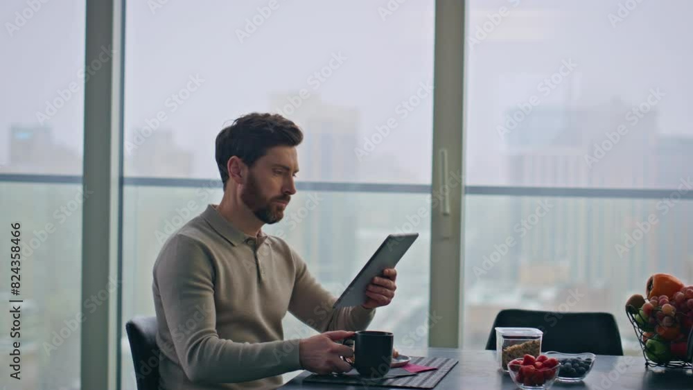 Focused freelancer chatting online looking tablet in glass apartment closeup Focused freelancer chatting online looking tablet in glass apartment closeup