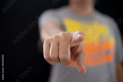 Asian man standing and pointing finger on black background