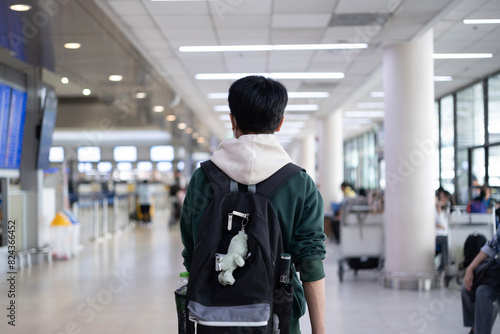 Behind the scenes is a boy with a backpack walking at the airport