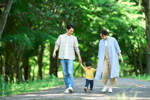 Fotografie 手を繋いで公園を歩く家族