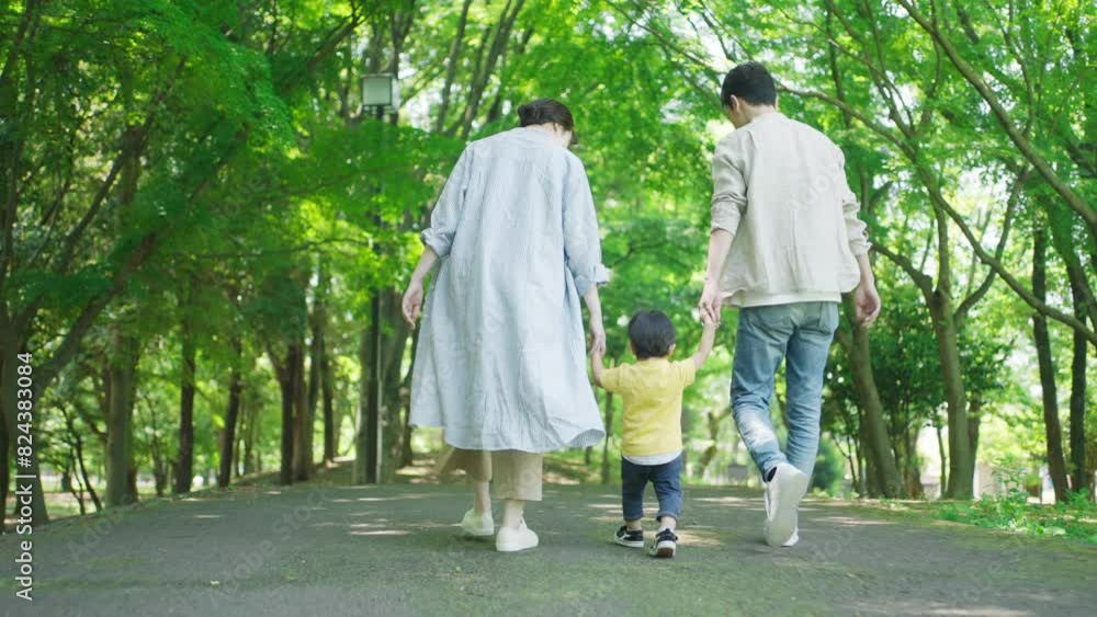 手を繋いで公園を歩く家族
手を繋いで公園を歩く家族