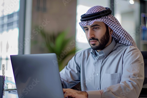 Arab man working on laptop in office