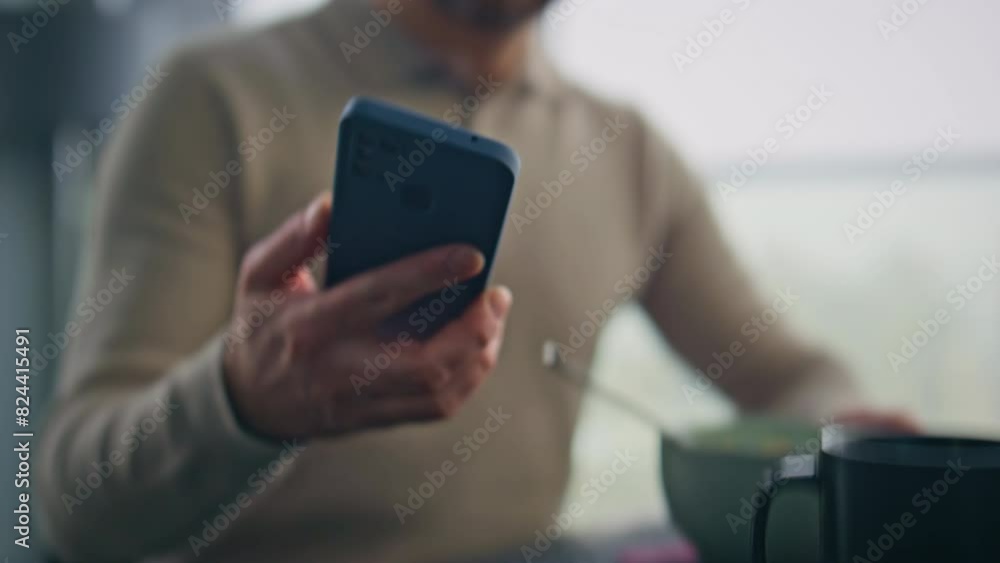 Eating man hand taking cellphone receiving notification at morning flat closeup Eating man hand taking cellphone receiving notification at morning flat closeup