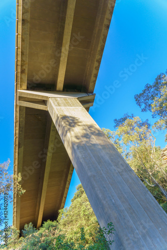 column of a concrete viaduct seen from below with a blue sky in the background