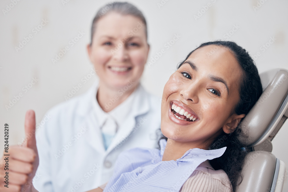 Happy woman, portrait and thumbs up with dentist for teeth cleaning, oral or gum care on chair at clinic. Female person with smile, like emoji or yes sign for tooth whitening, veneers or thank you Happy woman, portrait and thumbs up with dentist for teeth cleaning, oral or gum care on chair at clinic. Female person with smile, like emoji or yes sign for tooth whitening, veneers or thank you
