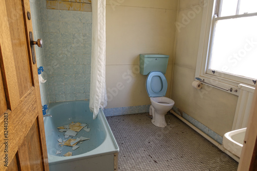 Canvastavla An old and dusty hotel bathroom and toilet with outdated interiors; wall tiles collapse and fall into the bathtub