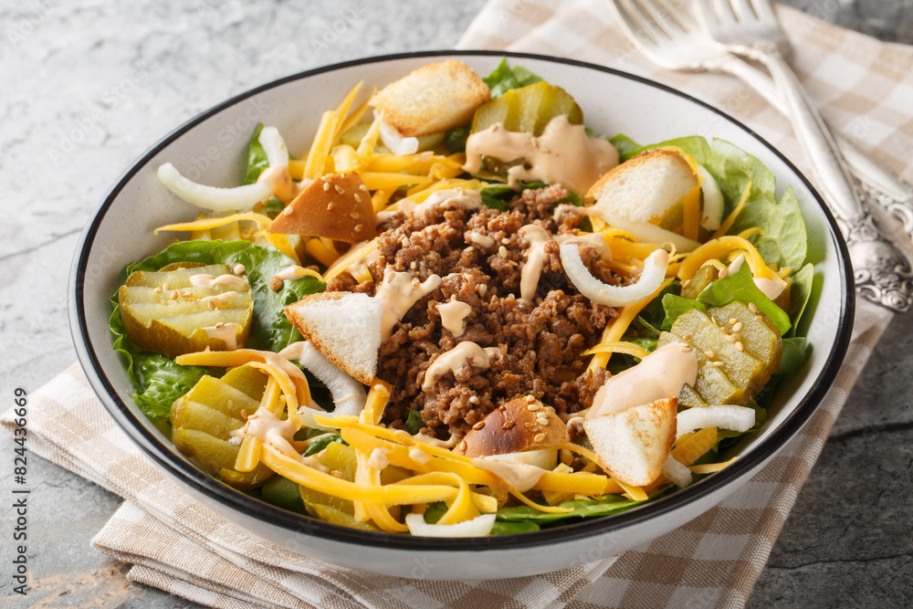 Cheeseburger, hamburger or burger keto salad with crunchy lettuce, creamy burger sauce, ground beef, pickles, cheese and onions closeup on the bowl on the table. Horizontal