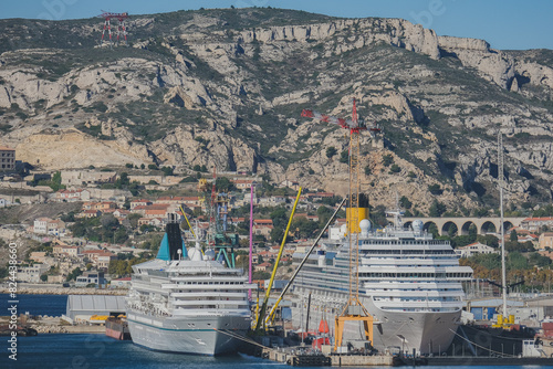 Classic and modern cruise ship cruiseship liners maintenance repair modernization refurbishment overhaul dry docked by French shipyard in Marseille, France with dock and cranes	 photo