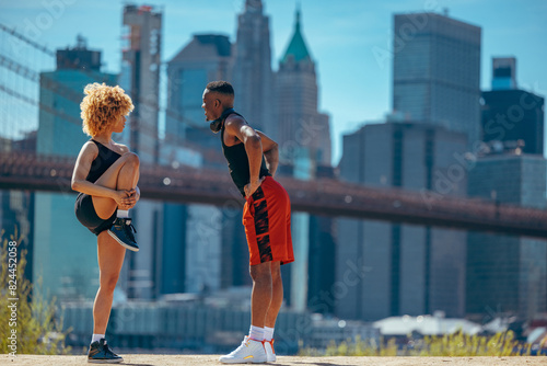 A man and a woman in sportswear stretching before a jog