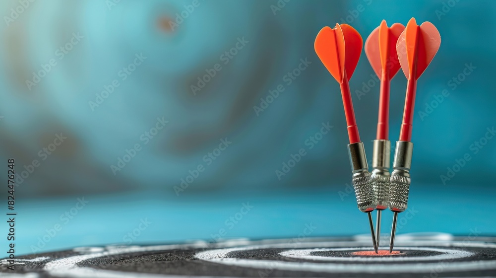 Fototapeta premium three red darts hitting the bullseye of a dartboard on a blurry blue background