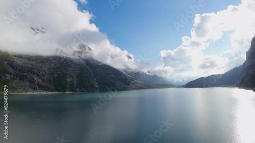 Aerial flight over a beautiful big Oeschinen lake on a mountain in Switzerland (ID: 824479679)