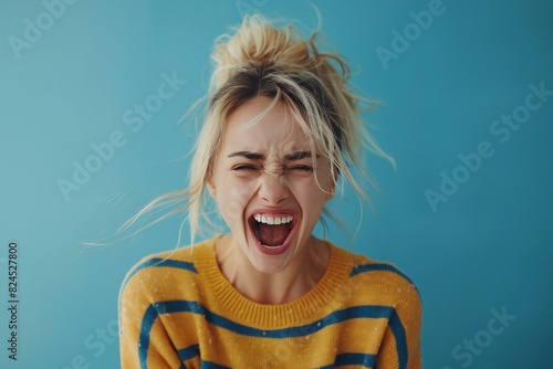 Woman screaming against blue background with no smiling photo
