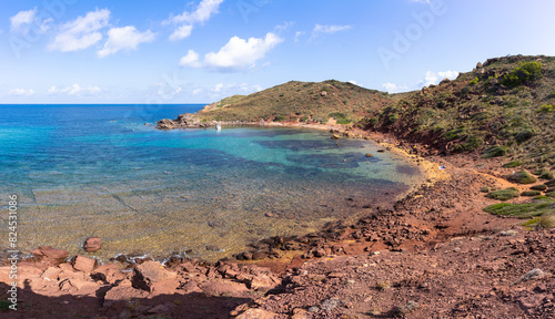 View of Cala Rotja, a little cove in the north of the island of Menorca, a stone and rock beach in a totally natural environment with little influx of tourists photo