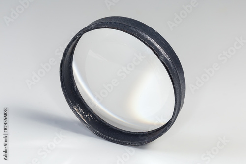 Simple plano-convex metal frame lens on a gray background