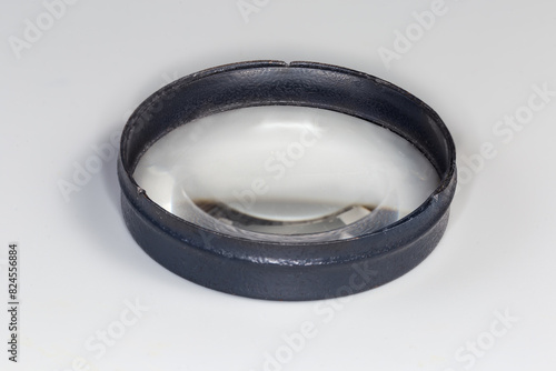 Simple plano-convex metal frame lens on a gray background