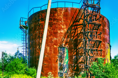 Old rusty oil tanks (fuel reservoir, oil barrel). Evidence of economic stagnation and environmental pollution