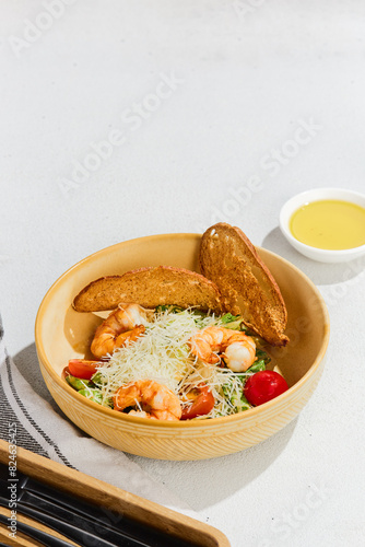 Fresh Shrimp Caesar Salad with Parmesan and Croutons on White Background photo