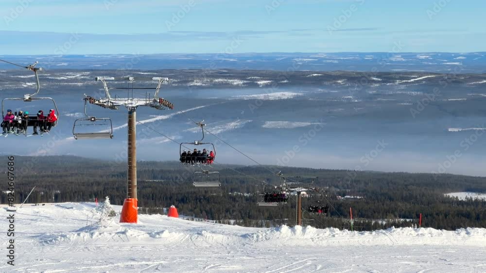 Winter ski lift chairlift up a ski slope during warm sunset in Sälen Sweden ski arena wintersport with deep snow and ice in cold and panoramic view across valley Winter ski lift chairlift up a ski slope during warm sunset in Sälen Sweden ski arena wintersport with deep snow and ice in cold and panoramic view across valley
