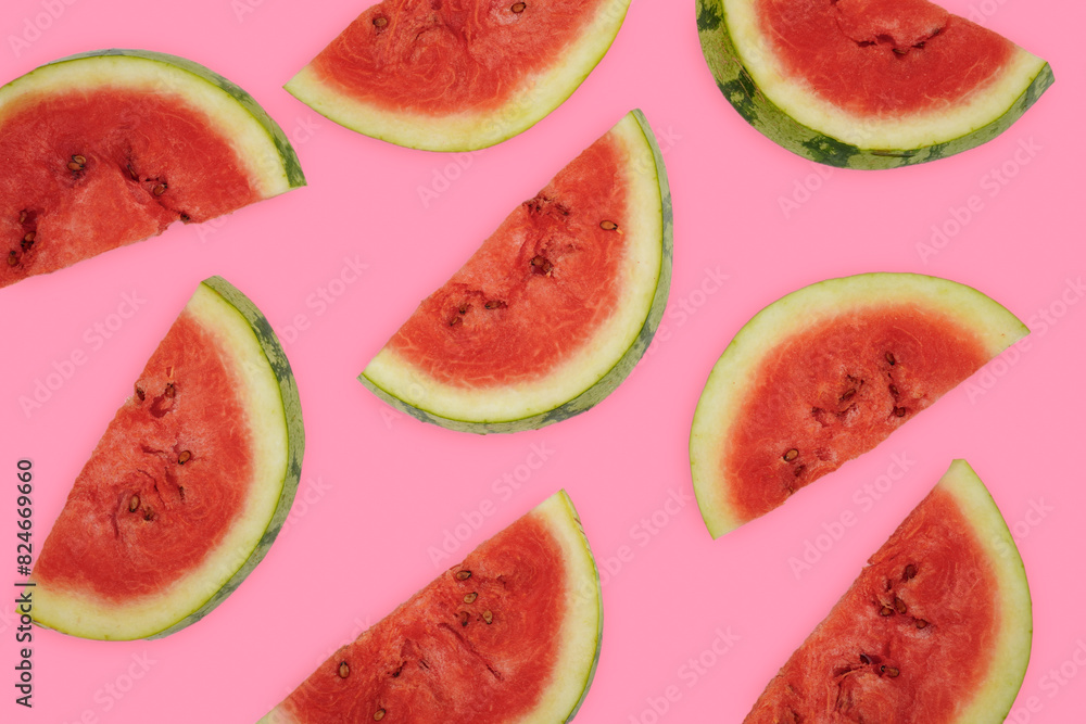Summer fruit background concept, half round watermelon cuts spread out over pink background Summer fruit background concept, half round watermelon cuts spread out over pink background