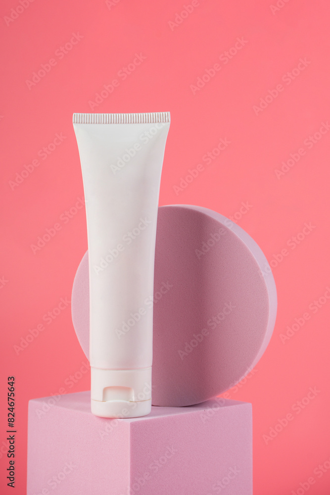 Plastic white tube for cream or lotion. Skin care or sunscreen cosmetic with stylish props on pink background. Plastic white tube for cream or lotion. Skin care or sunscreen cosmetic with stylish props on pink background.