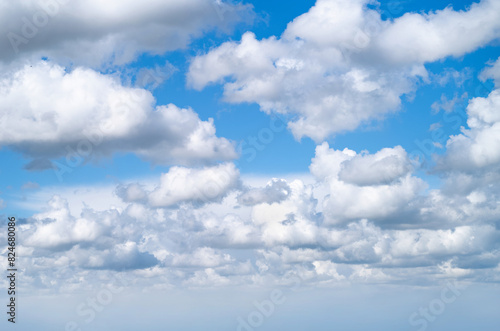 A spring, summer blue sky background with white fluffy clouds in a warm climate.