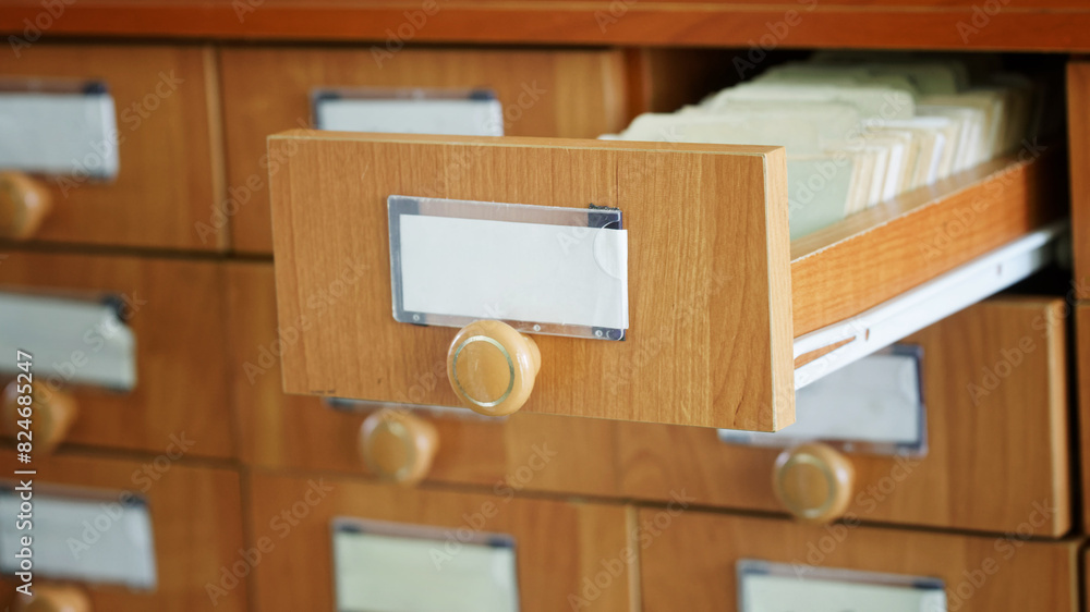 One open and many closed wooden paper filing cabinets. Archival storage of information and data. Search in old archives. Place for the inscription - mockup. Photo. Selective focus