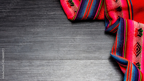Bright multicolor tablecloth on wooden table for background. Fabric texture. Wooden texture. Copy space. Top view	
