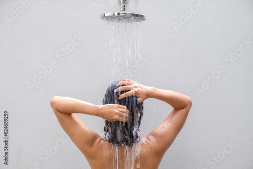 Beautiful woman's hand She was washing her hair and nourishing her scalp. Shampoo and conditioner	 photo