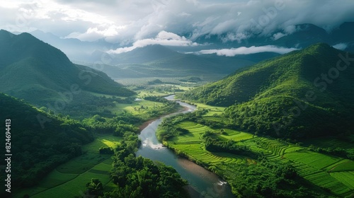A breathtaking aerial view of lush green valleys, a winding river, and misty mountains under a dramatic sky, perfect for nature enthusiasts.