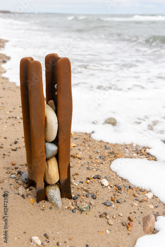 Old, decaying, rusty groyne by the sea, with stones, on Vane Tempest Beach in Seaham, County Durham, UK, formerly preventing erosion, Longshore Drift