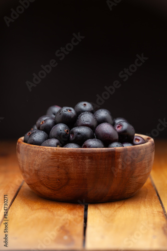 Wallpaper Mural A wooden bowl filled with 'Indian blackberry' or Jamun (Syzygium cumini) fresh fruits, on a dark background. Front view. Torontodigital.ca