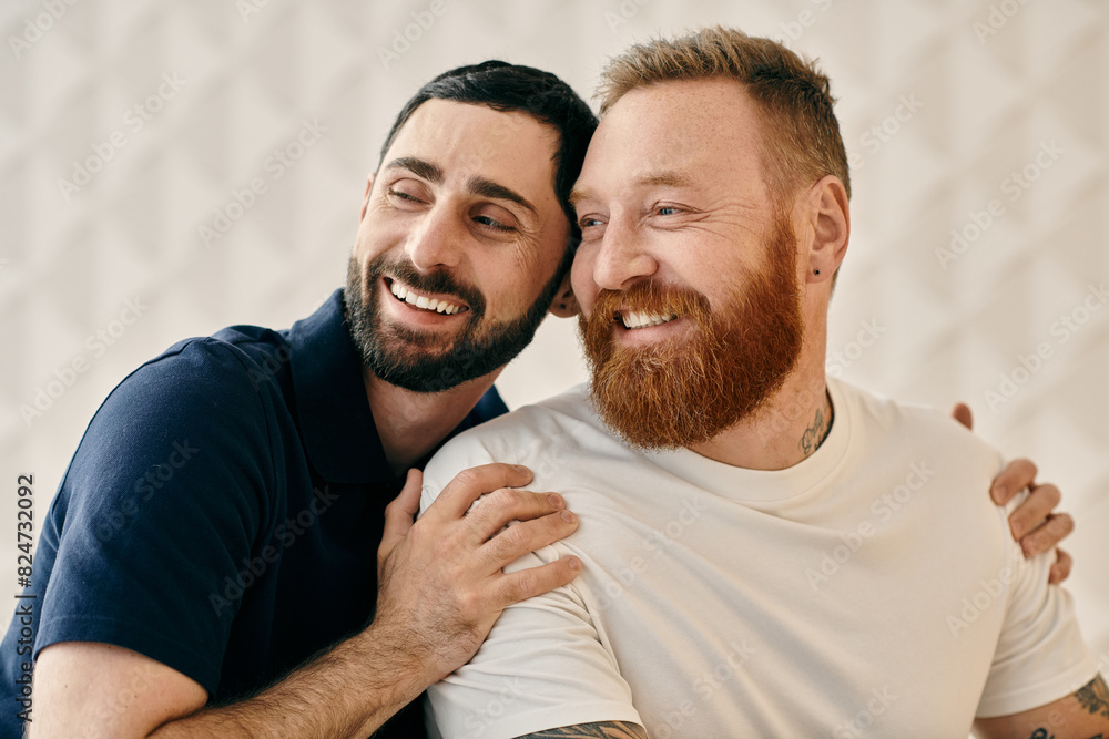 Two bearded men, happy and in love, hug tightly in a modern living room. Two bearded men, happy and in love, hug tightly in a modern living room.