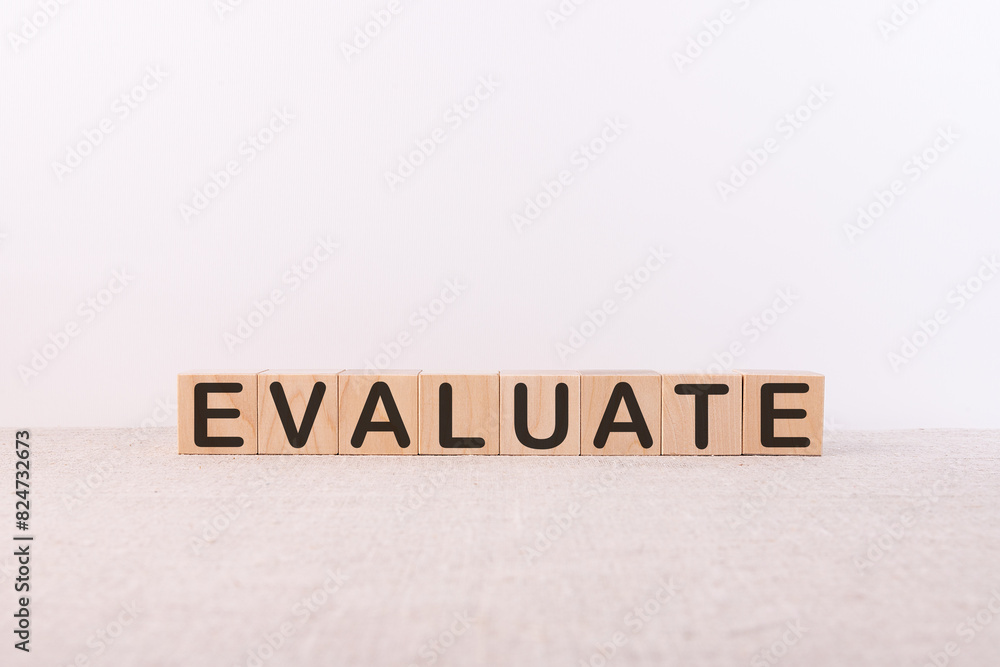 EVALUATE word concept written on wooden cubes on a light background EVALUATE word concept written on wooden cubes on a light background