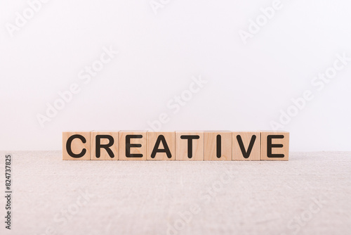 Word CREATIVE written on wooden cubes on a light background