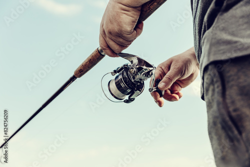 Freshwater fishing in summer. A fisherman using a spinning with a spinning reel to catch predatory freshwater fish.