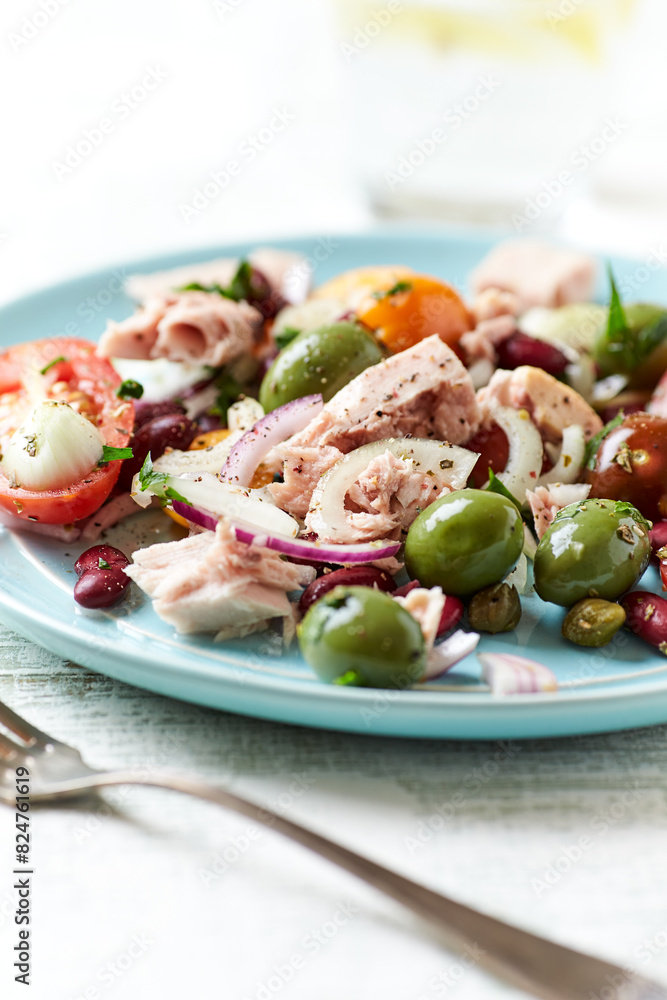 Salad with tuna, green olives and cherry tomatoes. Bright wooden background. Close up. Copy space. Salad with tuna, green olives and cherry tomatoes. Bright wooden background. Close up. Copy space.