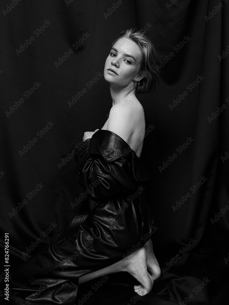 Naklejka premium Stylish fashion portraits of a beautiful girl in a cape with a short haircut and a slim figure
