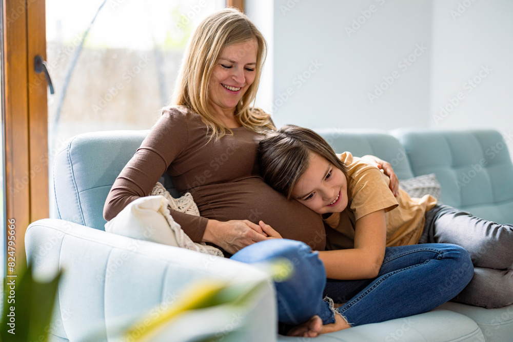 Little boy with his pregnant mother at home
