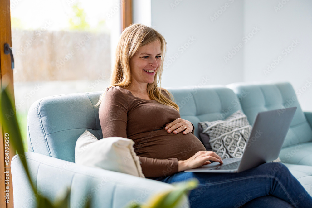 Obraz premium Pregnant woman working with laptop at home 