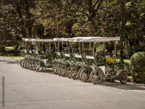 Four wheeled sightseeing pedal cars quadricycle quadracycle for rent parking in a park in Seville photo