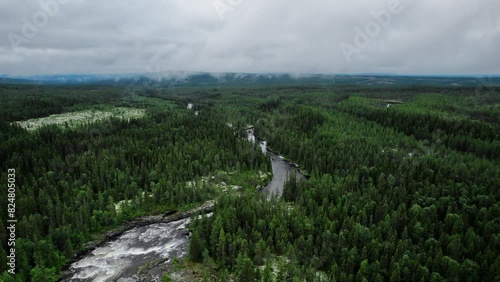 Drone descending above the beauty of Sognstupet Rapids in Idre, Dalarna, Sweden, showcasing the Storån river winding through dense forests photo