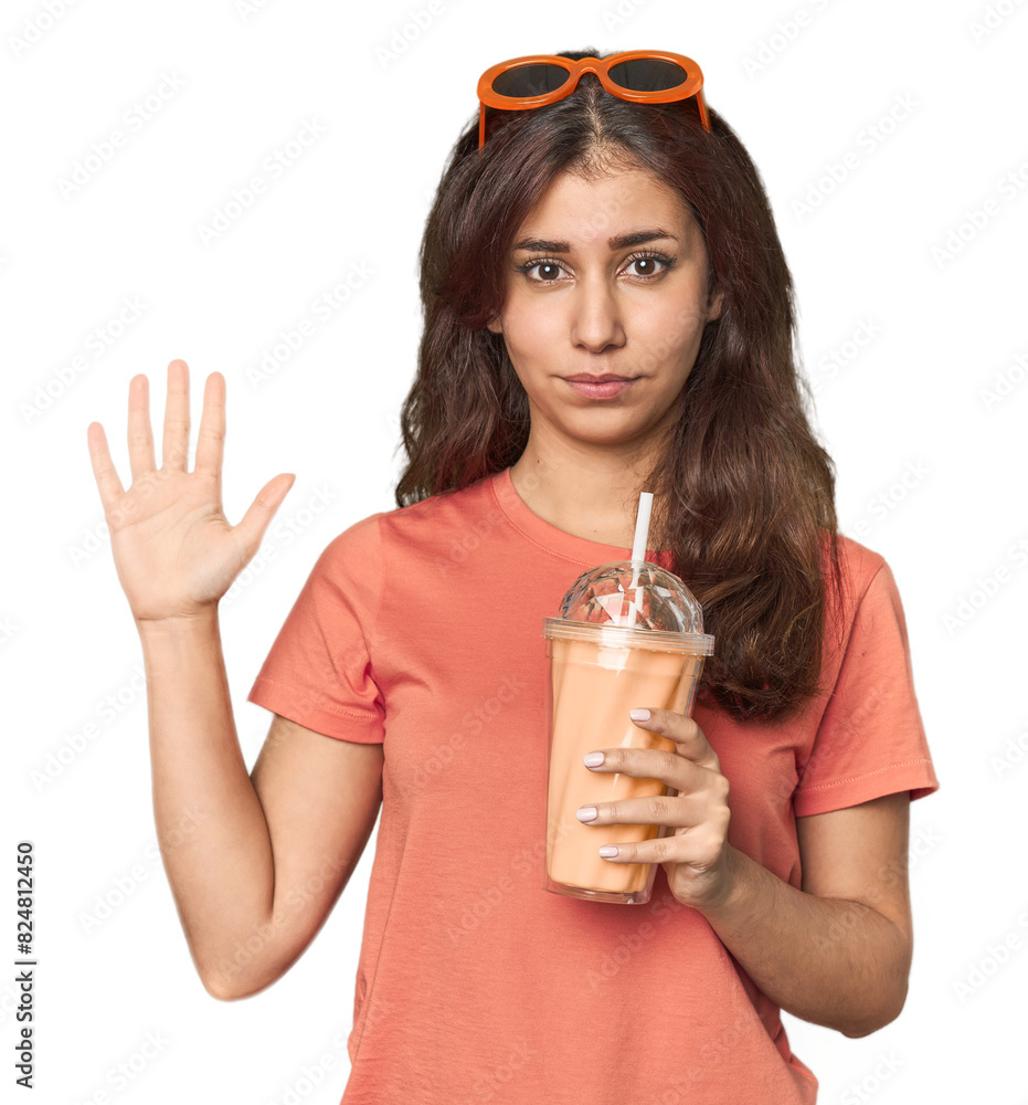 Fotografie Middle Eastern woman with smoothie smiling cheerful showing number five with fingers