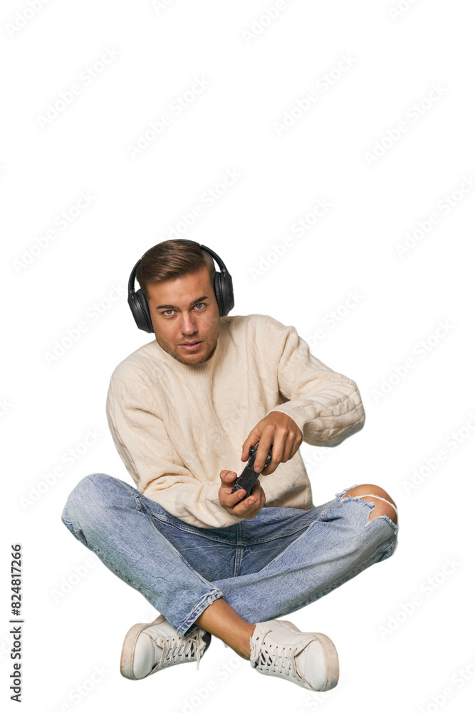 Young man playing video games with a controller on studio floor Young man playing video games with a controller on studio floor