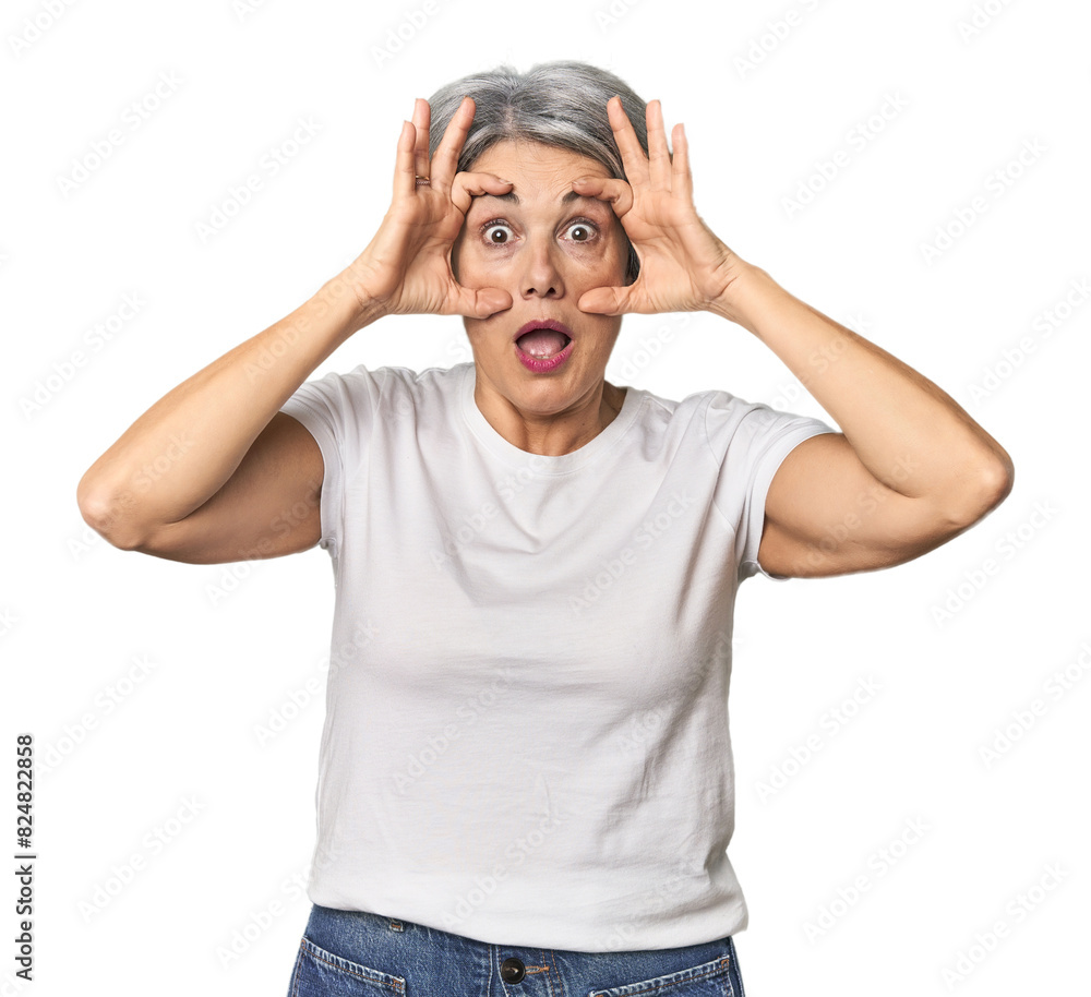 Caucasian mid-age female on studio background keeping eyes opened to find a success opportunity. Caucasian mid-age female on studio background keeping eyes opened to find a success opportunity.