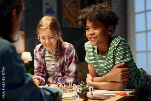 Canvas-taulu Cute smiling youthful boy in striped t-shirt looking at one of friends during di