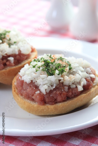 mettbrötchen with onions on wooden table