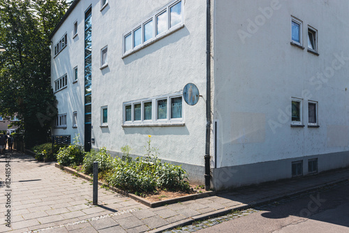 Weiße Fassade eines Reihenhauses in der Ernst-May-Siedlung Frankfurt mit bepflanztem Vorgarten