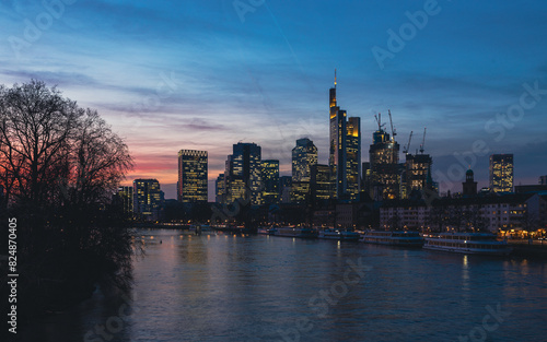 Skyline von Frankfurt am Main bei Abendrot mit Hochhäusern und Fluss