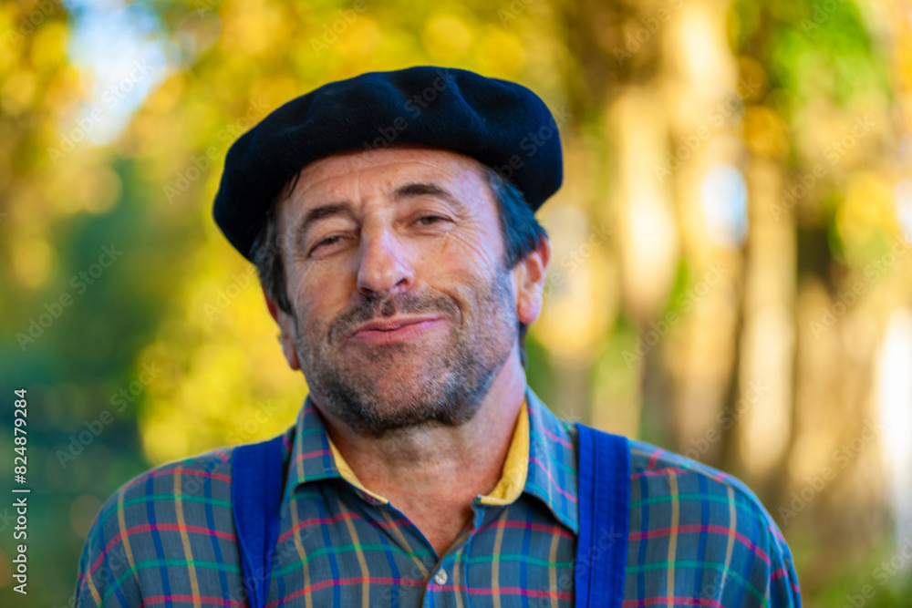 Portrait of a Frenchman, wearing a beret and blue dungarees smiling and gesticulating to camera Portrait of a Frenchman, wearing a beret and blue dungarees smiling and gesticulating to camera